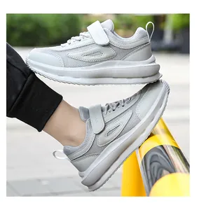 Vista laterale dettagliata di scarpe da ginnastica grigie in mesh traspirante per bambini.