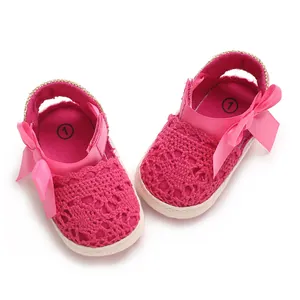 Close-up detail of breathable pink lace newborn baby sandals with a decorative bow