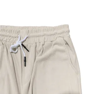 Détail d'un pantalon en velours côtelé beige avec taille élastique et cordon blanc