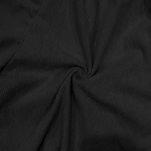 Macro detail showing the rich texture and vertical ribs of black corduroy fabric for shorts