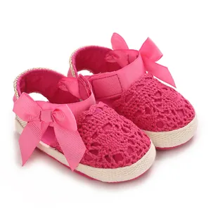Detailed macro view of pink lace infant baby girl sandals with decorative ribbon bows