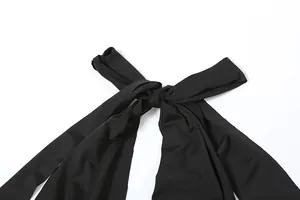 Detail van de elegante zwarte halterstrik op een zomerse jurk met een open rug