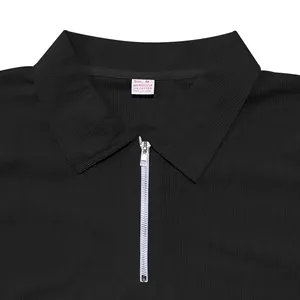 Macro detail of black ribbed polo shirt with silver zipper and fabric composition tag.
