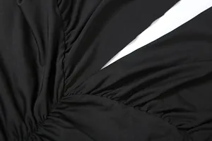 Detail van de elegante zwarte geplooide V-hals op een zomerse maxi-jurk