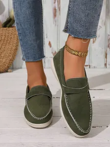 Nahaufnahme von dunkelgrünen Wildleder-Loafers für Damen mit eleganten weißen Ziernähten