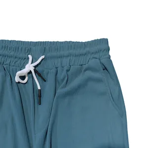Détail de la taille d'un pantalon en velours côtelé bleu avec cordon blanc