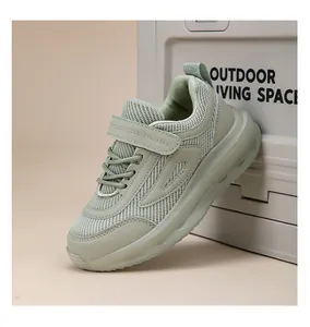Dettaglio di scarpe da ginnastica per bambini in mesh verde salvia con cinturino in velcro.