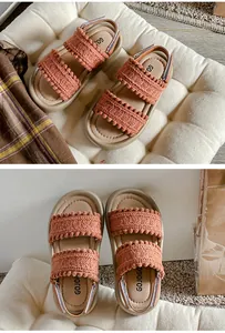 Detail view of retro woven girls' sandals with pom-pom trim and soft soles