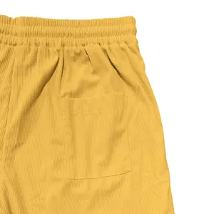 Close-up of yellow corduroy shorts showing elastic waistband and back pocket detail