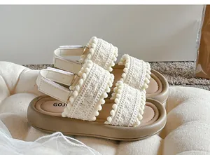 Detail of girls vintage crochet sandals featuring soft soles and cute pom-pom trim