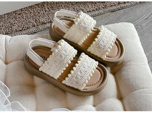 Detail of retro kids' open-toe sandals with white crochet straps and brown soft soles