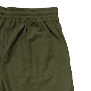 Detailed macro shot of olive green corduroy men's shorts featuring elasticated waistband.