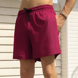 Detail van bordeauxrode sneldrogende sportshort met geweven textuur en trekkoord