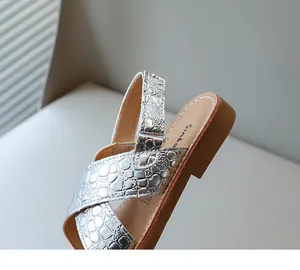 Vista dettagliata della texture coccodrillo argento metallizzato sui sandali estivi per bambina