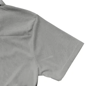 Macro detail of men's grey polo shirt showing textured fabric and sleeve stitching