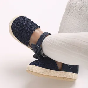 Macro view showing navy blue lace baby girl princess shoes with bow and rubber sole