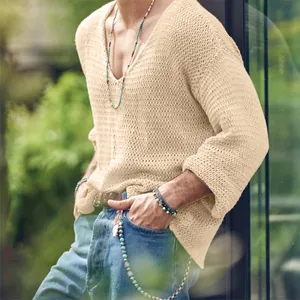 Detailed macro view of men's hollow-out knit sweater showing V-neck and texture.