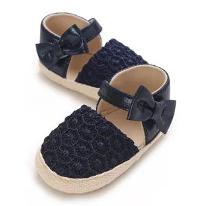 Detailed macro view of baby girl princess shoes with navy lace pattern and glitter bow