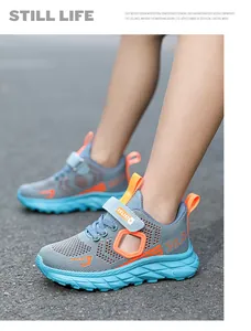 Detailed side view of boys breathable mesh sports shoes with vibrant orange accents