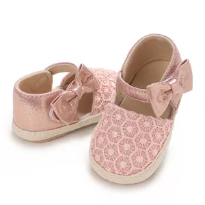 Close-up of pink baby girl princess shoes with lace pattern and cute bow detail