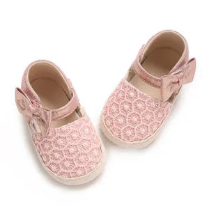 Close-up of pink baby girl princess shoes featuring decorative bow and lace-like mesh upper