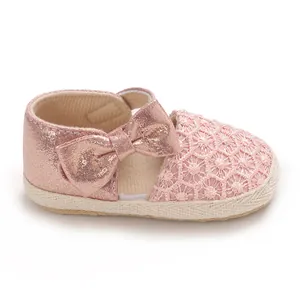 Close-up detail of adorable pink baby princess shoe featuring glittery bow and lace