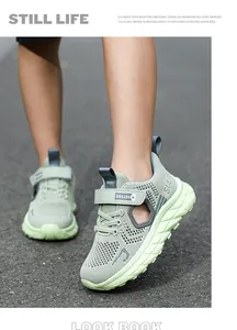 Close-up of boys' breathable mesh running shoes in light green on an outdoor path