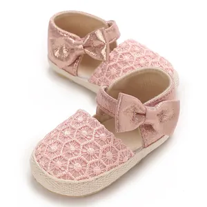 Detailed view of pink baby girl princess shoes with bow knot and floral lace pattern