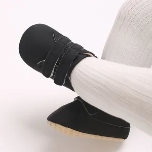 Gros plan de baskets noires antidérapantes pour bébé avec bandes auto-agrippantes.