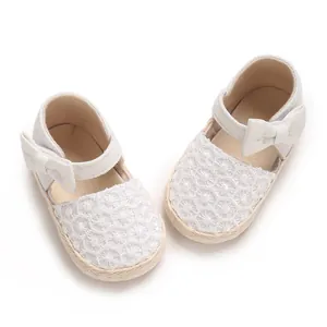 Close-up view of white baby girl princess shoes featuring delicate lace pattern and cute bow detail