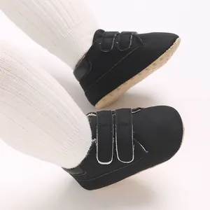 Vue détaillée de baskets noires minimalistes pour bébé avec fermeture velcro aux pieds