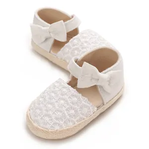 Detailed macro view of white baby girl princess shoes featuring lace and a decorative bow