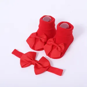 Primer plano detallado del conjunto de calcetines de bebé rojos con lazos y diadema a juego