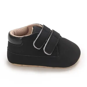 Close-up of black baby boy sneaker detail showing hook-and-loop straps and matte finish