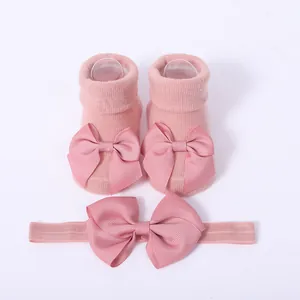 Vista detallada de calcetines rosa para bebé y diadema a juego con lazos decorativos