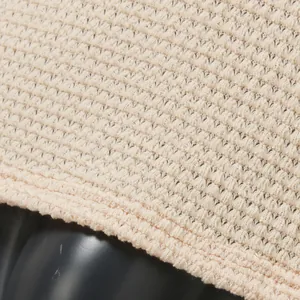 Macro detail of beige hollow knit fabric showing intricate breathable weave texture