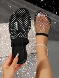 Close-up van zwarte mesh platte sandalen met fonkelende strass-steentjes
