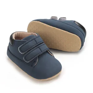 Baskets pour bébé bleu foncé avec velcro et semelle souple antidérapante pour premiers pas.