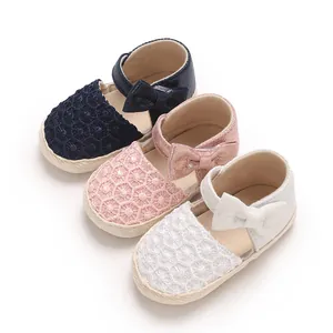 Close-up of baby girl lace sandals with bow accents and soft soles in various colors