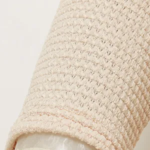 Detailed macro shot of beige retro hollow-out knit fabric showing textured pattern