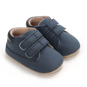 Détail de chaussures de sport bleu marine pour bébé garçon avec brides velcro réglables.
