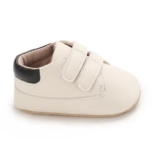 Detail view of off-white baby sneaker featuring black heel patch and double velcro straps