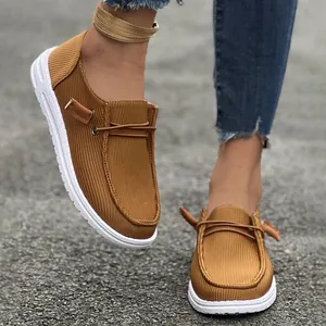 Dettaglio di mocassini slip-on in velluto a coste marrone da donna con suole piatte e stile casual