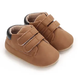 Gros plan de baskets pour bébé en similicuir marron avec double bande velcro, 0-1 an.