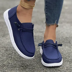 Vista dettagliata dei mocassini da donna blu navy a coste con suole bianche spesse.