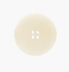 Macro view of a natural creamy white tagua nut button featuring a classic four-hole design