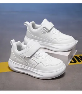 Detalle de zapatillas blancas para niños con suela gruesa y cierre de velcro.