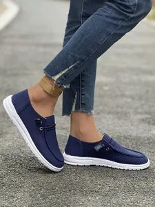 Dettaglio dei mocassini casual blu navy a coste con suola piatta bianca e lacci laterali