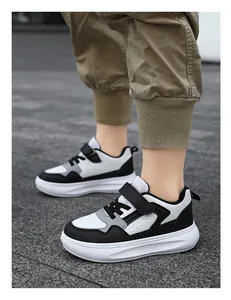 Detalle de zapatillas de cuero blanco y negro con suela gruesa para niños en exterior