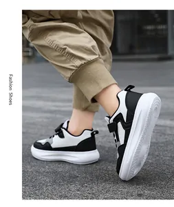 Primer plano de zapatillas de cuero blanco y negro para niños con suela gruesa